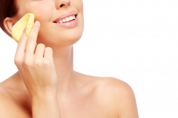 mujer con esponja, limpieza facial